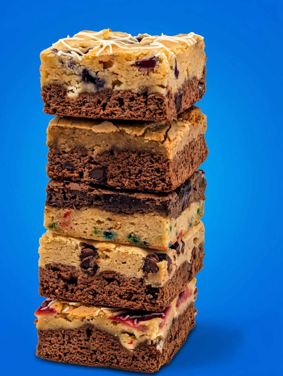 Tall stack of large Buckabee brookies showing layered brownie and blondie textures with mix-ins including blueberry, chocolate chip, oreo and strawberry