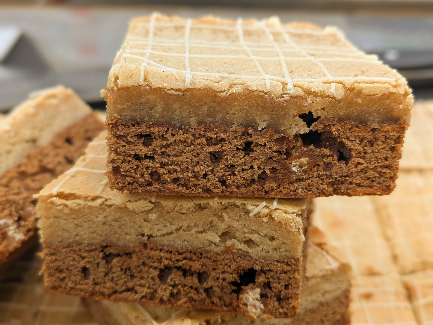 Extreme close-up of two Butterscotch Cinnamon Brookie bars stacked cut-side out, highlighting the distinct two-layer interior of pale butterscotch blondie and darker cinnamon brownie.