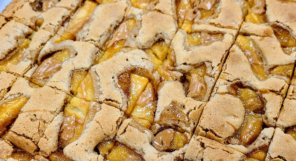 Macro close-up of Buckabee Brownies Caramel Apple Blondie showing glossy caramel-coated apple chunks embedded in cinnamon blondie base