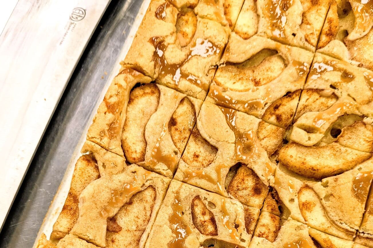 Close-up of freshly baked Caramel Apple Blondie in pan with caramel-coated apple pieces and cinnamon spice, cut into squares