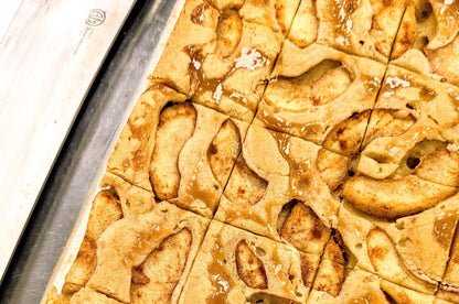 Close-up of freshly baked Caramel Apple Blondie in pan with caramel-coated apple pieces and cinnamon spice, cut into squares