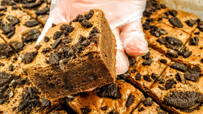 Cookies & Cream Brownie in hand with pan